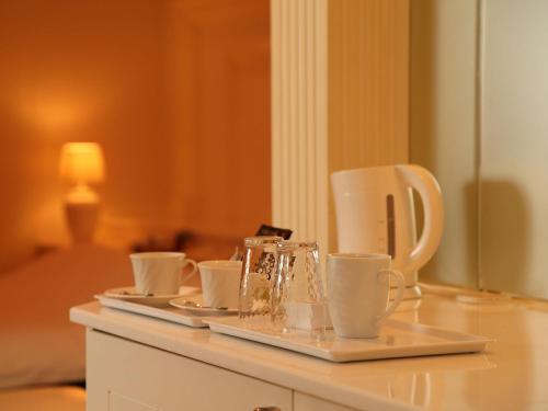 a tray with cups and saucers on a table at Hotel Fine Garden Gifu in Kakamigahara