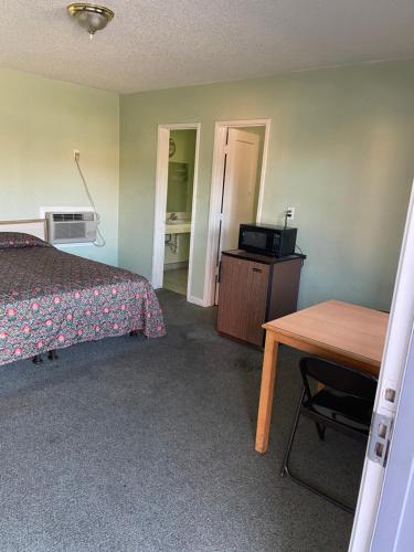 - une chambre avec un lit, un bureau et une table dans l'établissement RAMONA MOTEL, à Hemet