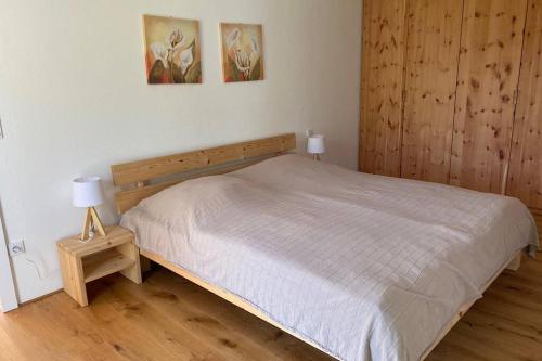 a bedroom with a bed and two lamps on a wooden floor at Nachhaltiges Wohnen in Seenähe in Schömberg