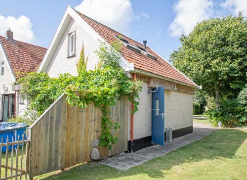 a house with a gate and a fence at Eendrachtweg 4 in De Cocksdorp