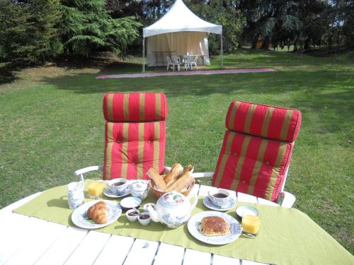 une table avec une assiette de nourriture et deux chaises dans l'établissement Etape Zen, à Illiers