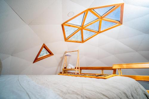 a bedroom with a bed and a window on the ceiling at Tantakuy Eco Experience Hotel in La Huaica
