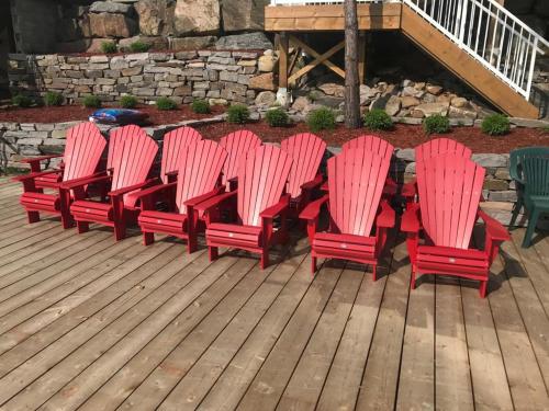 a group of red chairs sitting on a deck at Muskoka Lakes Hotel and Resorts in Port Carling
