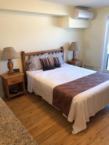 a bedroom with a large bed with two night stands at Muskoka Lakes Hotel and Resorts in Port Carling