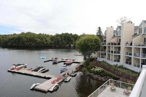 a dock with boats in the water next to a building at Muskoka Lakes Hotel and Resorts in Port Carling