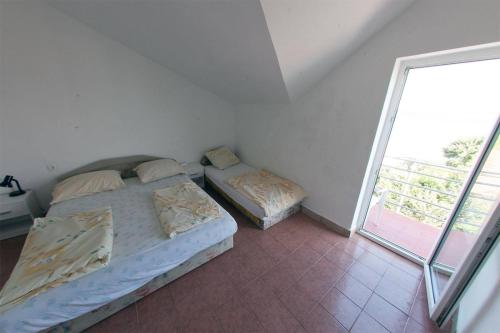 a bedroom with two beds and a large window at Apartments Rado - close to the sea in Tkon