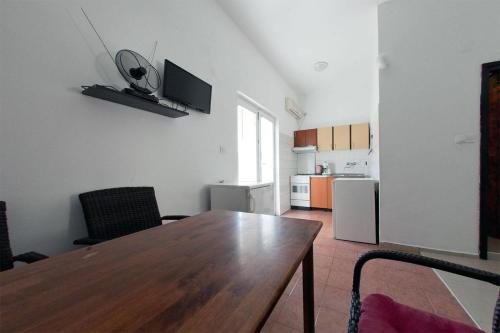 a living room with a wooden table and a kitchen at Apartments Rado - close to the sea in Tkon