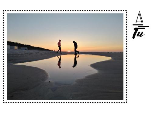 two people walking on the beach at sunset at A morze TU in Gdynia