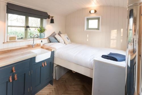 a small bedroom with a bed and a sink at Oak + Stars Hideaway in Holmfirth