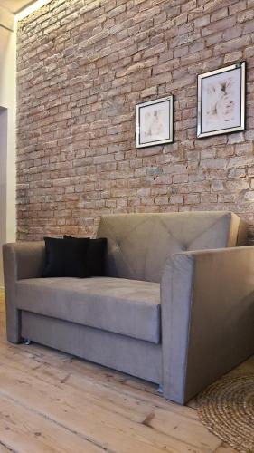 a couch in a room with a brick wall at Apartament Za Murami Gliwice in Gliwice