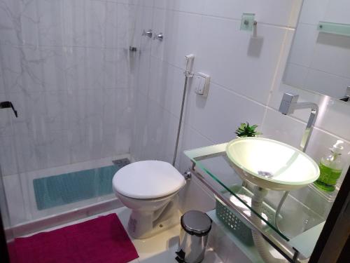 ein Badezimmer mit Waschbecken, Toilette und Badewanne in der Unterkunft Ensolarado ao lado do shopping com garagem e Wifi in Teresópolis