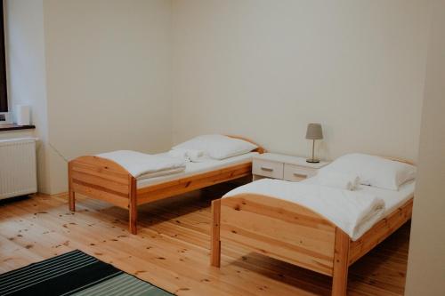 two beds in a room with wooden floors at Zamkowa, Pokoje Gościnne in Kazimierz Dolny