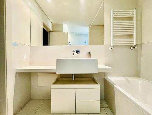 a white bathroom with a sink and a bath tub at ABC Expo Apartment in Lisbon