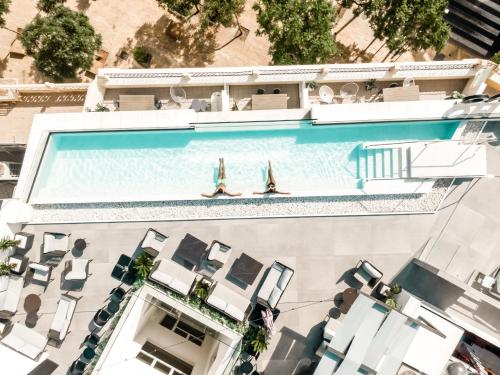 two people are swimming in a swimming pool at HO Puerta de Purchena By Olivencia in Almería