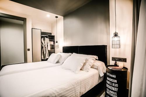 a bedroom with a bed with white sheets and pillows at HO Puerta de Purchena By Olivencia in Almería