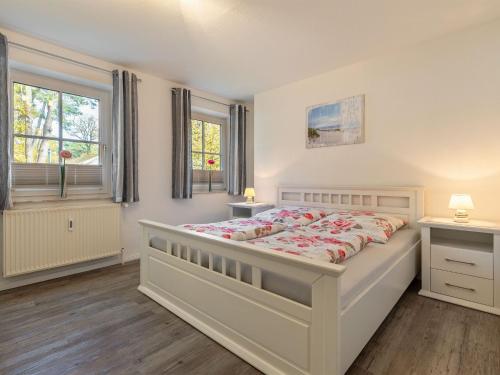 a bedroom with a large bed and two windows at Stunning Apartment in Boltenhagen in Boltenhagen