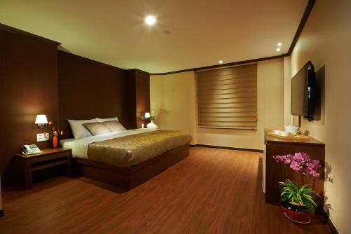 a bedroom with a bed and a flat screen tv at Hotel Four Seasons in Jeju
