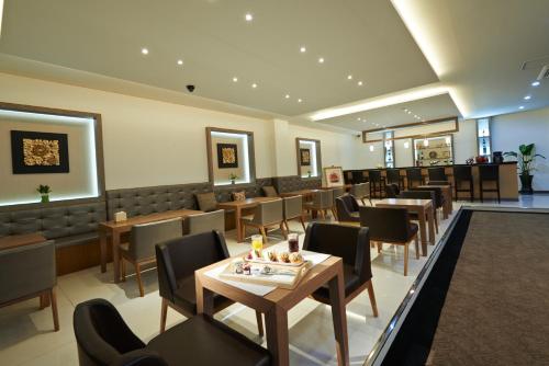 a dining room with tables and chairs in a restaurant at Hotel Four Seasons in Jeju