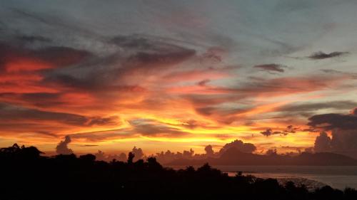 a sunset over the ocean with a cloudy sky at Manava Tahara'a Home Stay in Mahina