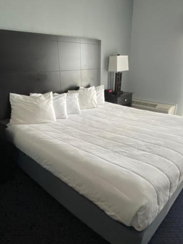 a large white bed in a hotel room at Lakeside Resort & Conference Center in Houghton Lake