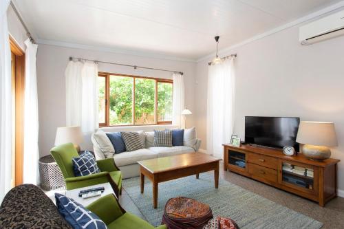 a living room with a couch and a tv at Solomon Street Cottage in Fremantle