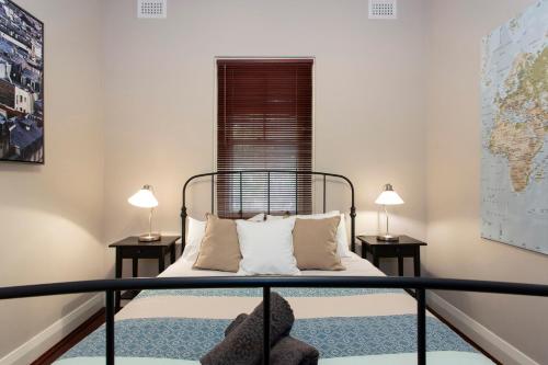 ein Schlafzimmer mit einem Bett mit zwei Lampen auf zwei Tischen in der Unterkunft Solomon Street Cottage in Fremantle
