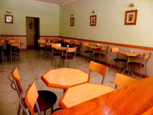 a restaurant with wooden tables and chairs in a room at Gran Hotel Oriental in Buenos Aires