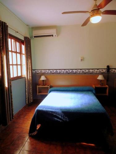 a bedroom with a bed and a ceiling fan at Gran Hotel Oriental in Buenos Aires