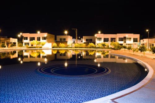 a swimming pool at night with buildings in the background at Casa Vacacional Flandes in Flandes