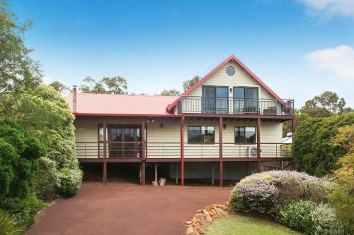 a large yellow house with a pink roof at The Tree House Dunsborough in Dunsborough