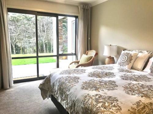 a bedroom with a bed and a large window at Road Sun Tourist Lodge in Dunedin