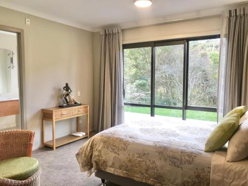 a bedroom with a bed and a large window at Road Sun Tourist Lodge in Dunedin