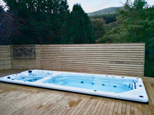 a jacuzzi tub sitting on a wooden deck at Road Sun Tourist Lodge in Dunedin
