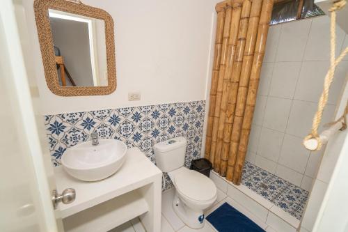 a bathroom with a toilet and a sink at Ganso & Búho in Ayampe