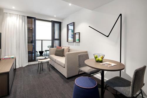 a living room with a couch and a table at Quest St Kilda Road in Melbourne