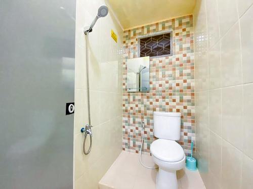 a bathroom with a toilet and a shower at Damigalova Guest House Mitra RedDoorz in Jambi