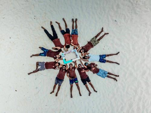 a group of people laying in a circle on the beach at Sabba Beach Suite , Fodhdhoo - Maldives in Velidhoo