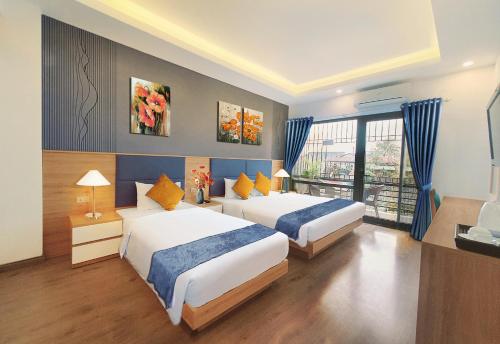 a hotel room with two beds and a window at Hanoi Amorita Boutique Hotel & Travel in Hanoi