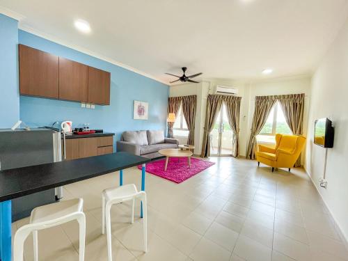 a kitchen and living room with a table and chairs at Tiara Desaru Seaview Residence in Desaru