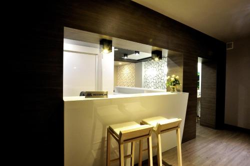 a kitchen with two stools and a counter with a mirror at Hostel Promenada in Rzeszów