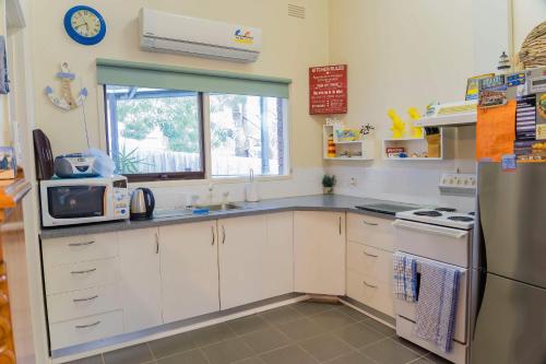 a kitchen with white cabinets and a window at Holiday Home in the Heart of Anglesea in Anglesea