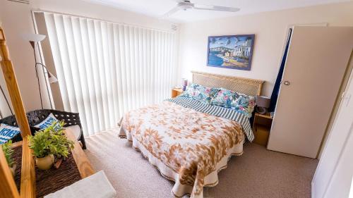 a bedroom with a bed and a window at Holiday Home in the Heart of Anglesea in Anglesea