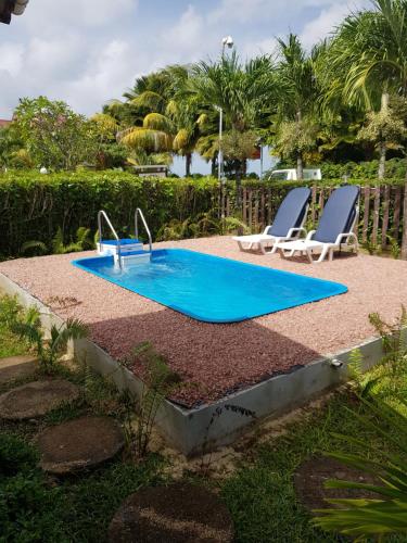 a swimming pool with two lounge chairs next to it at Villa Creole in La Digue