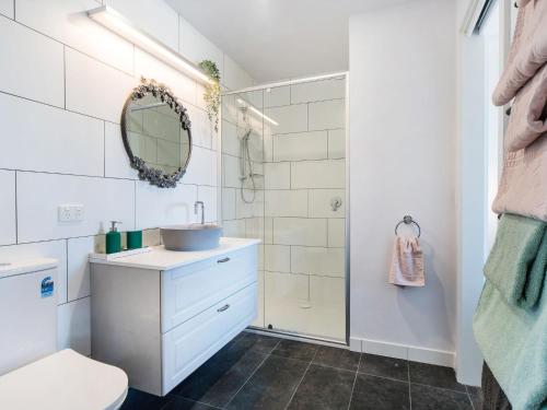 a white bathroom with a sink and a mirror at Seaside Escape in Mornington