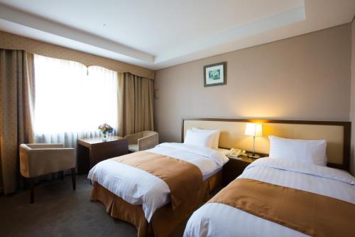 a hotel room with two beds and a window at Hotel Samjung in Seoul