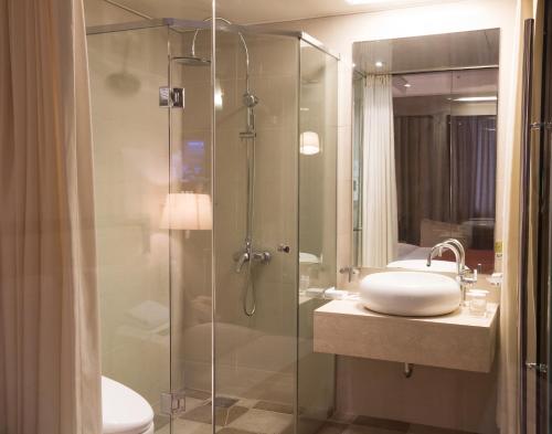 a bathroom with a glass shower and a sink at Hotel Samjung in Seoul