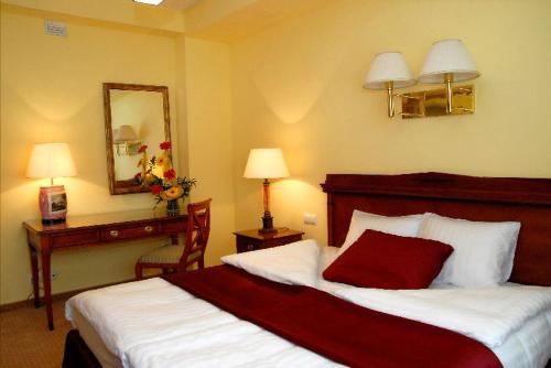 a hotel room with a bed and a mirror at Hotel Wilga by Katowice Airport in Pyrzowice