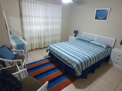 a bedroom with a bed with a striped blanket at Como Unit 5 in Gold Coast