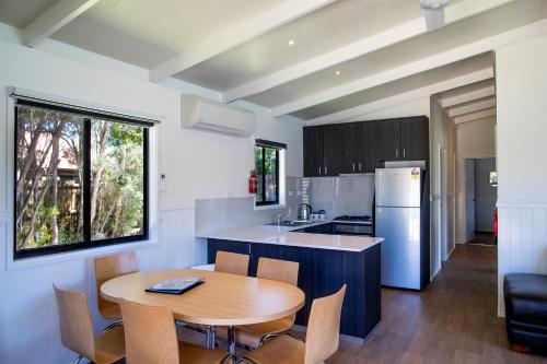 a kitchen with a wooden table and a dining room at BIG4 Ingenia Holidays Inverloch in Inverloch