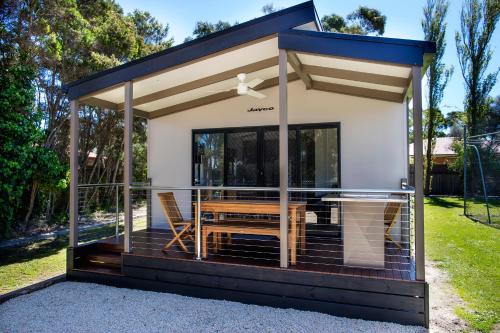 a tiny house with a deck with a table at BIG4 Ingenia Holidays Inverloch in Inverloch